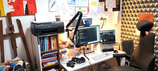 a desk with two computers and a printer on it