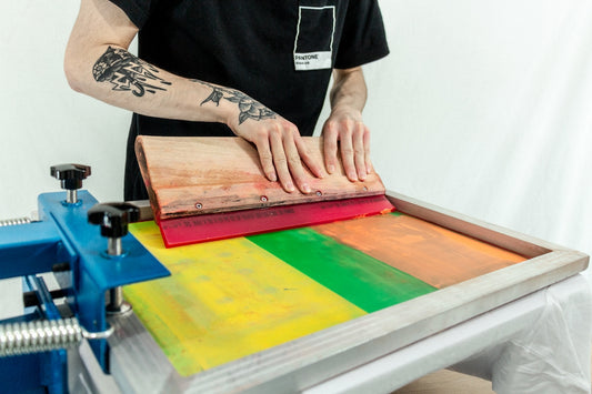man in black t-shirt standing beside brown wooden table