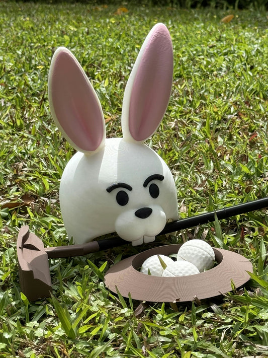 A bunny golfing with his equipment on grass.