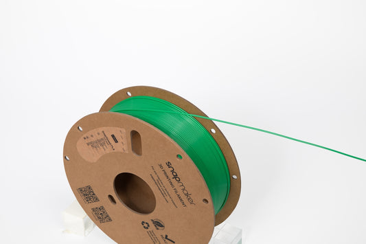 A green filament spool ready for 3D printing.