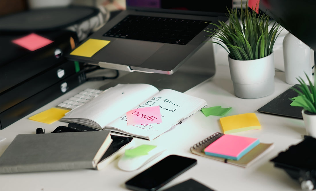 A cluttered desk with various office supplies.